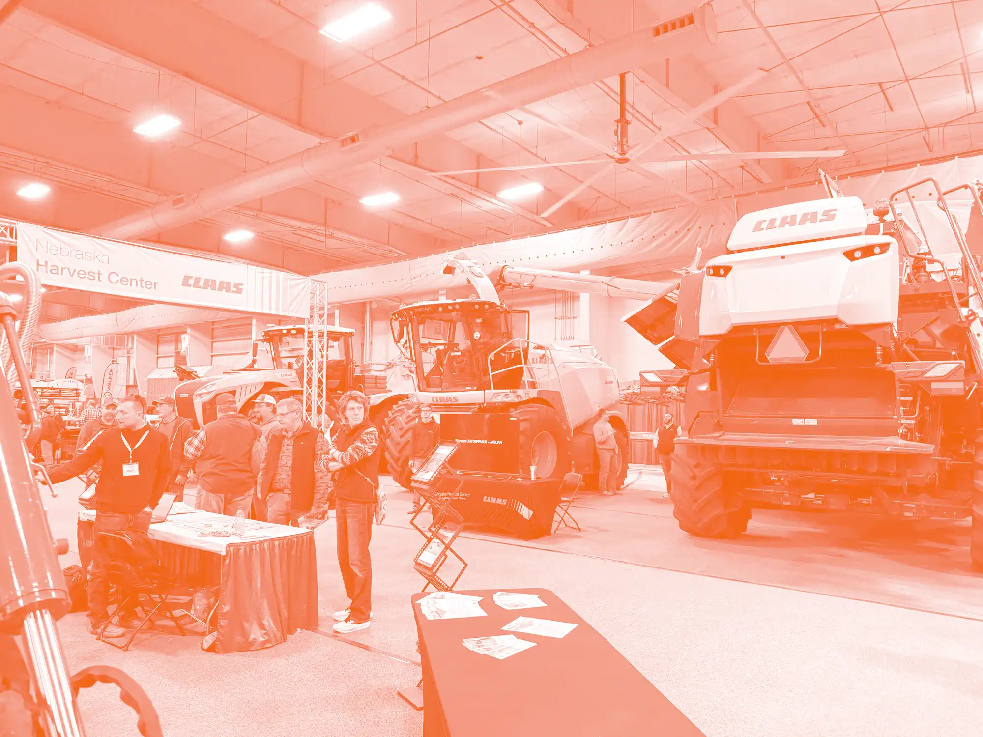 A row of heavy farm machinery lines the edge of the CLAAS booth at the Nebraska Ag Expo.